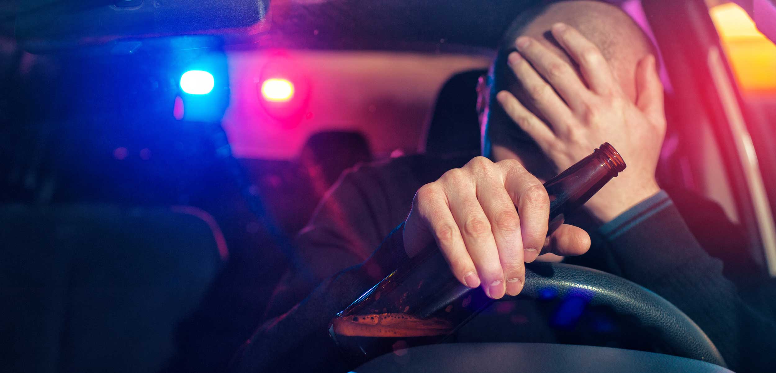 Drunk driver pulled over by cops with bottle in his hand