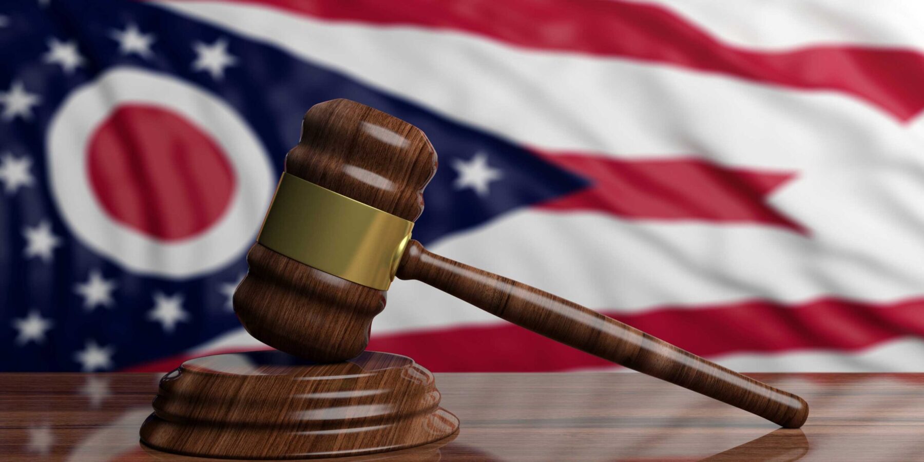 Ohio flag with judge's gavel in front on a wooden table
