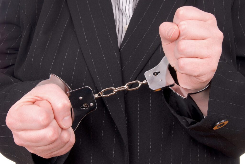 Business person in suit in handcuffs
