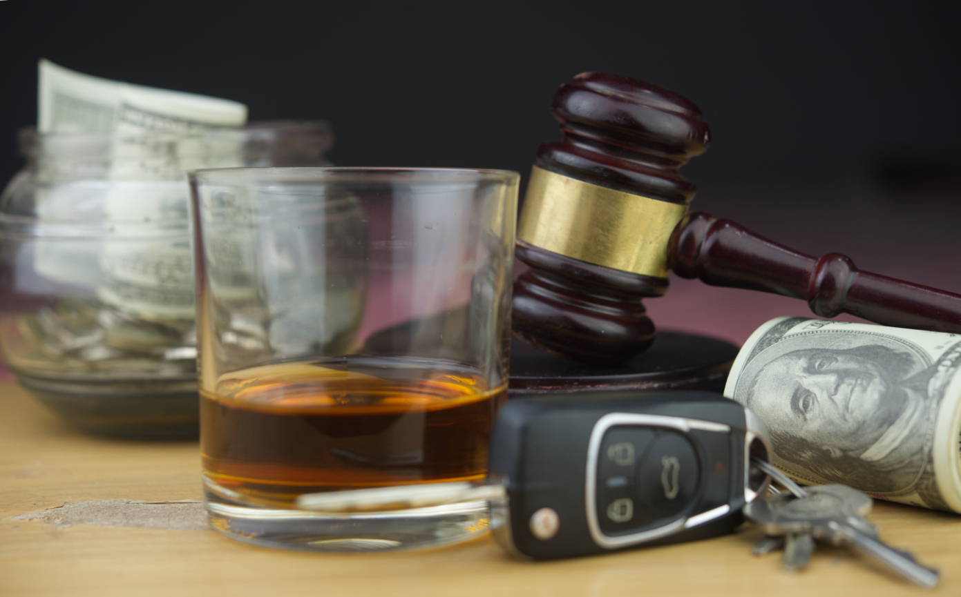 Glass of whiskey with car keys and a judges gavel, symbolizing an OVI charge